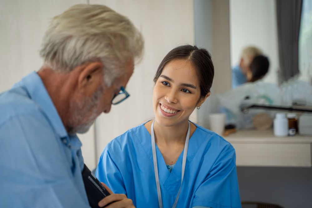 Care worker taking blood pressure of elderly man