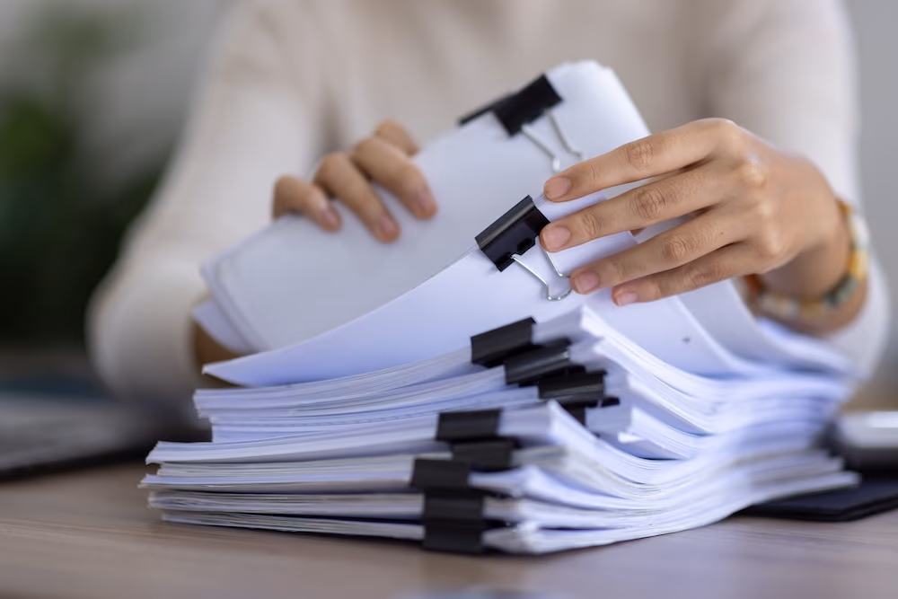 woman looking through a pile of documents 